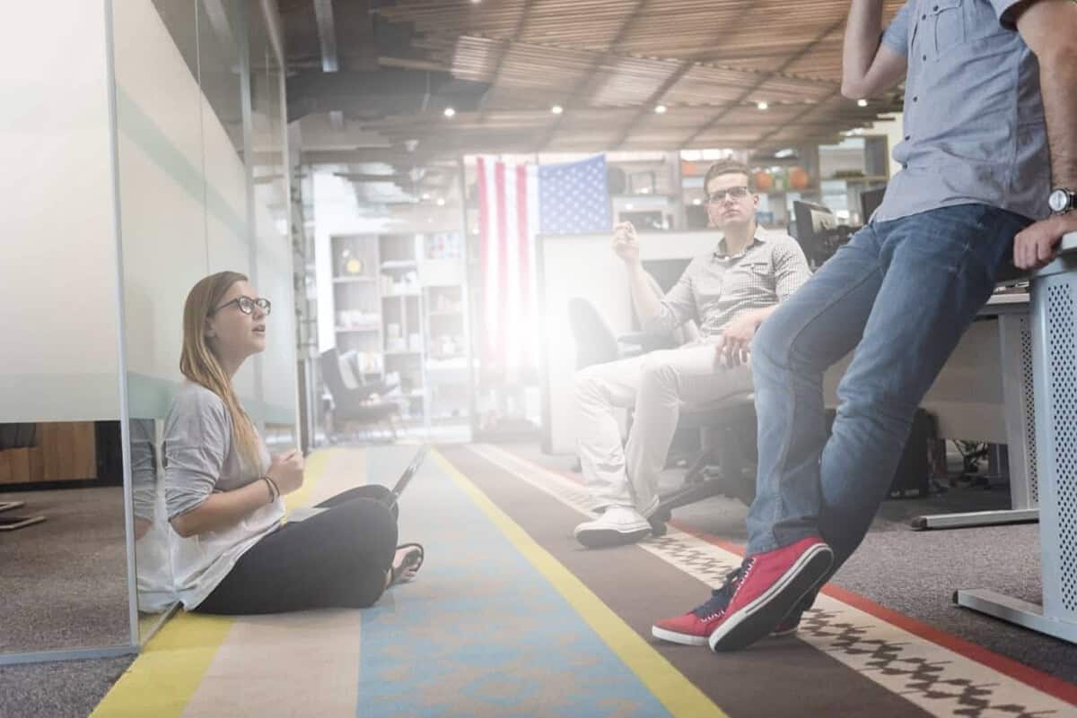 Website support team discussing website management services in office with American flag