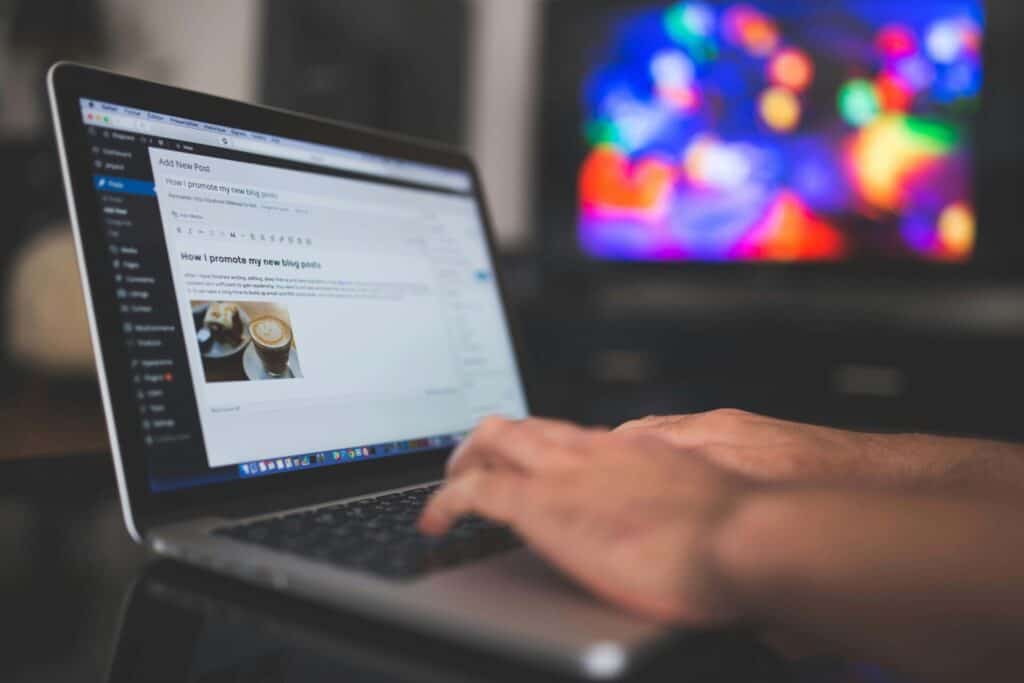 typing on a laptop with blog post visible