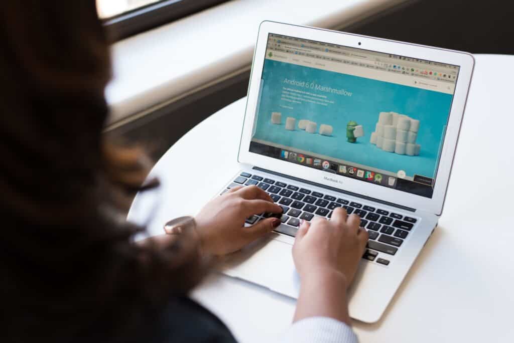 Businesswoman working on laptop with Android 6.0 Marshmallow webpage open